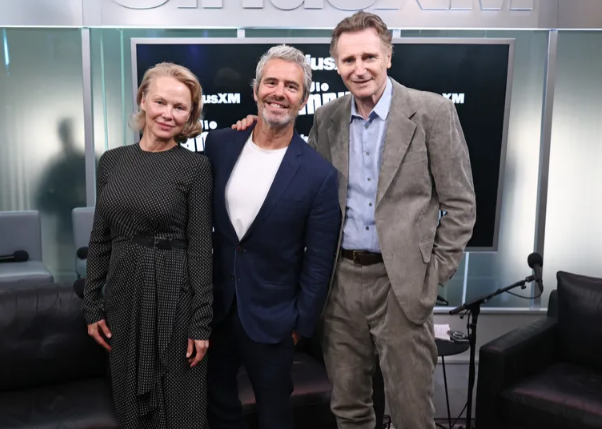 (L-R) Pamela Anderson, Andy Cohen, and Liam Neeson attend SiriusXM’s Town Hall with the cast of “The Naked Gun,” hosted by Andy Cohen at SiriusXM Studios on July 30, 2025, in New York City. | Source: Getty Images

